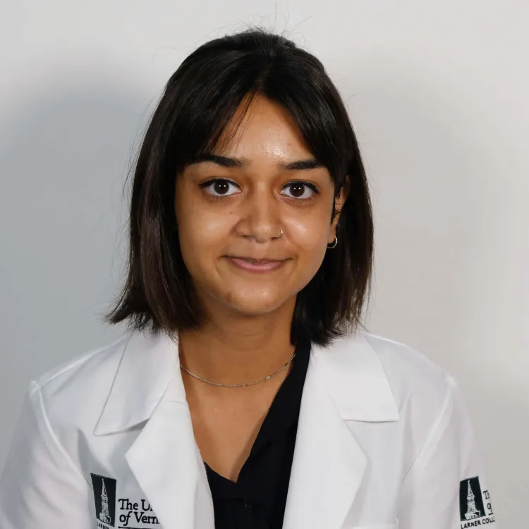 A person with shoulder length hair in a white coat