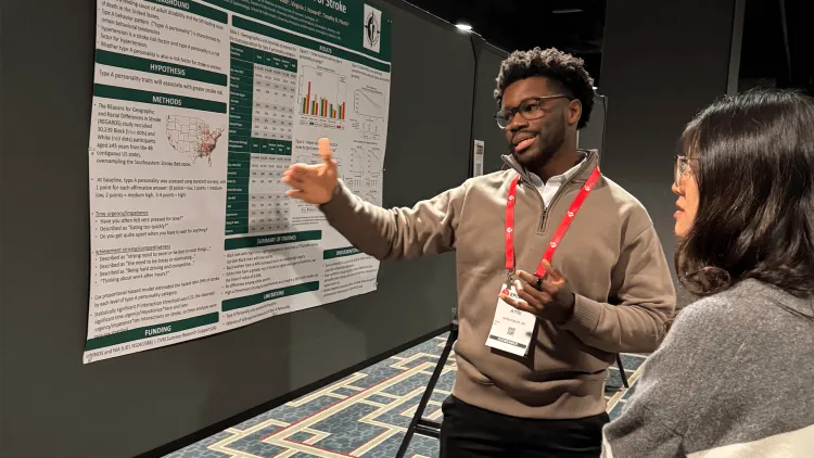 a man explaining his poster at a conference