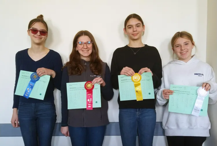 4 kids holding ribbons and certificates