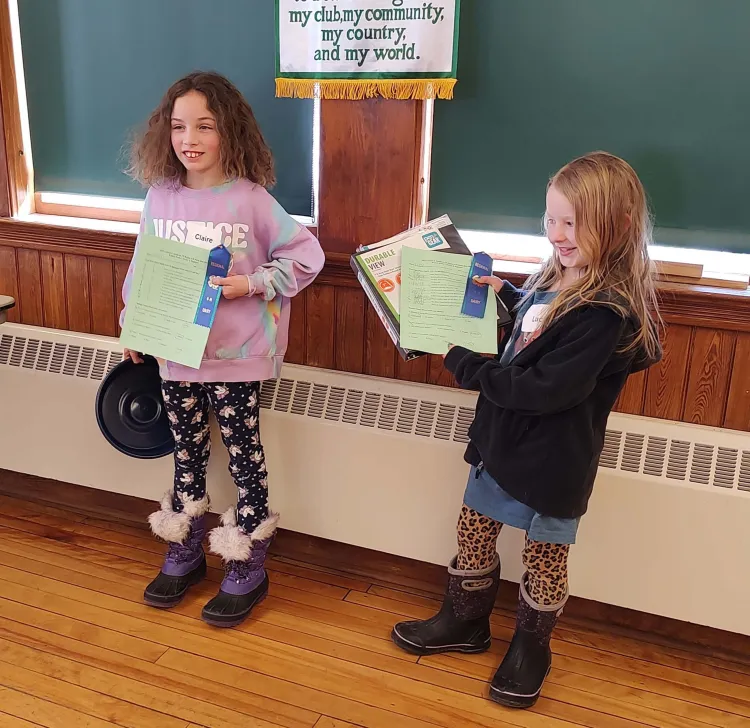 2 4-h'ers posing with certificates and ribbons