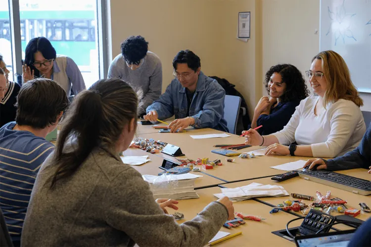 a group of students decorating paper bags at a table