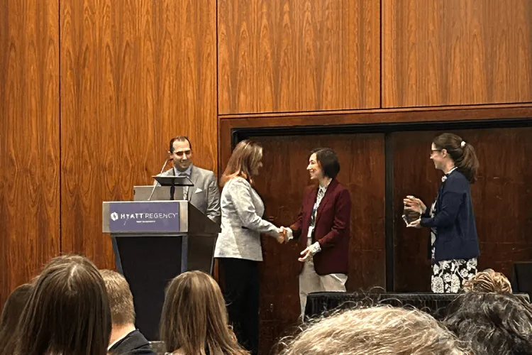 a woman accepting an award as people look on