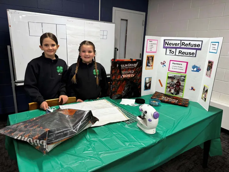 4-H'ers at a table presenting work
