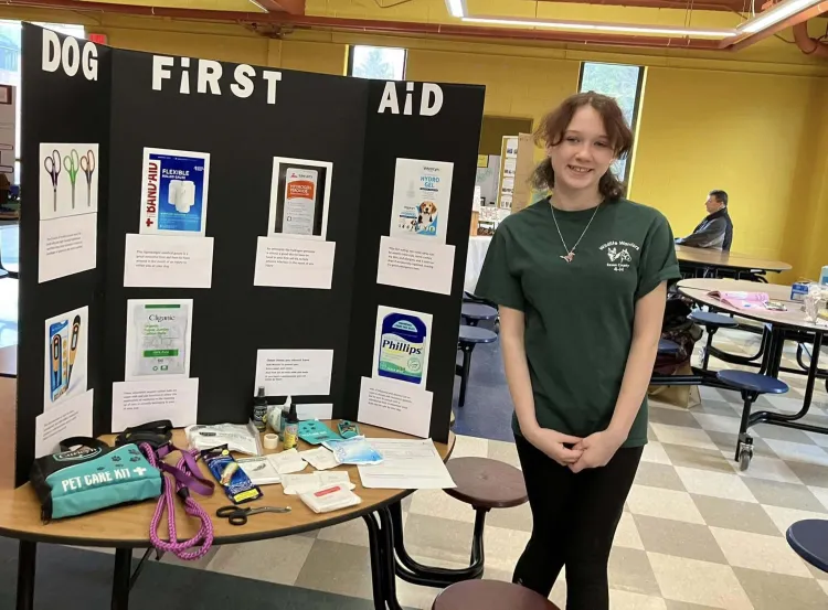 4-H'er at a table presenting work