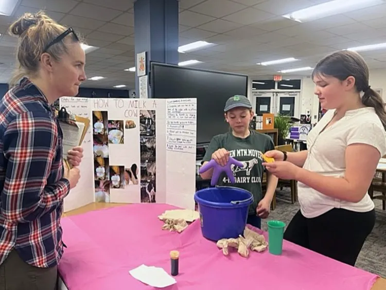 4-H'ers at a table presenting work