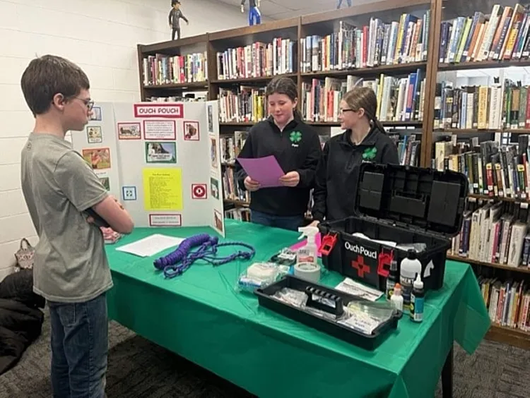 4-H'ers at a table presenting work