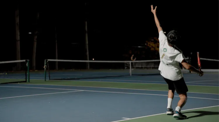 Student playing tennis