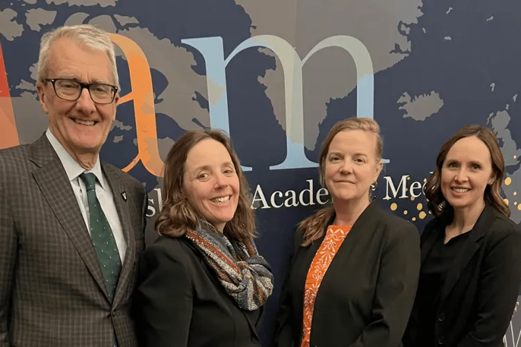 4 people posing at a conference