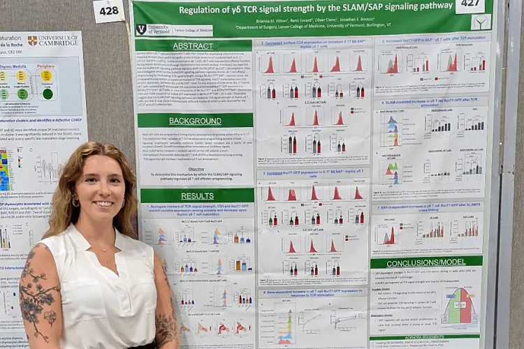 a woman smiling in front of a poster