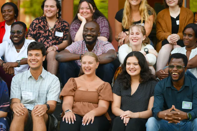 Group of HESA students smiling together at reception event.