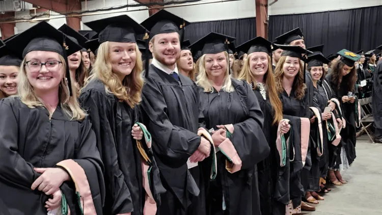 students in academic regalia at a graduation