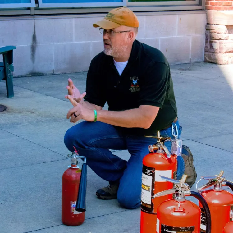 Previous Burlington Fire Marshall & current Fire Marshal/Deputy Emergency Manager at UVM, Barry Simays, explains to audience how to use a fire extinguisher. (2024) 