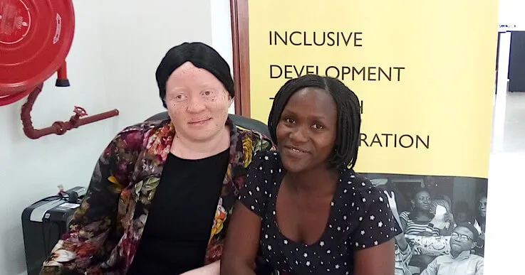 Woman smiling with a child with a disability.