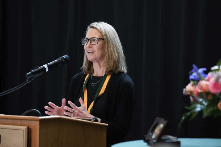a woman smiling at a podium