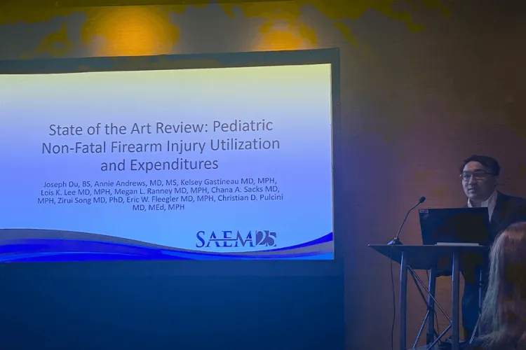a man at a podium with a big screen in the background