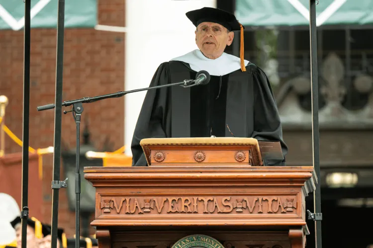 a man in academic regalia at a podium