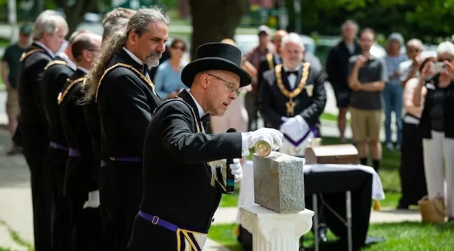 man annointing ceremonial cornerstone