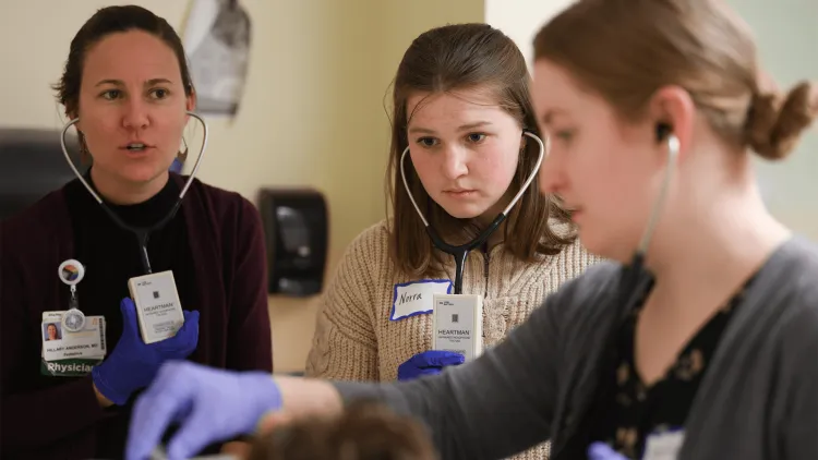 3 women with stethoscopes examining a patient