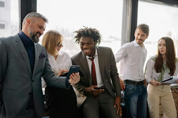 five business casual people laughing in an office