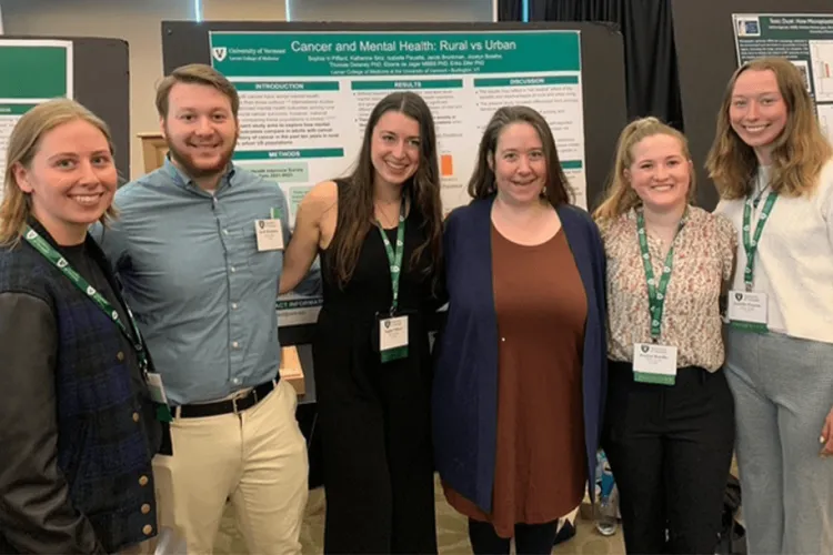 a group of people posing with a poster at a conference