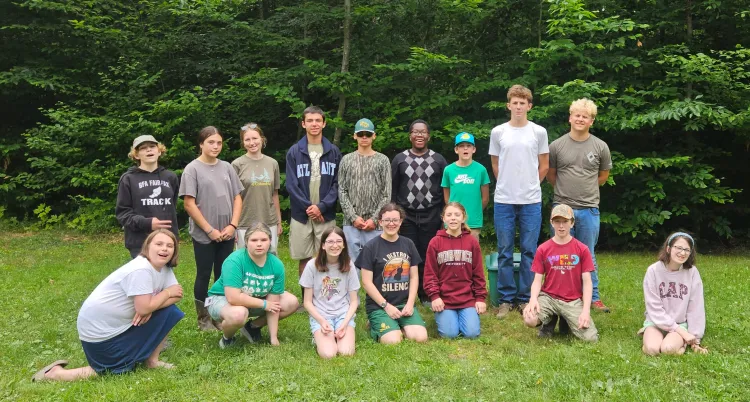 a group of kids posing in front of trees