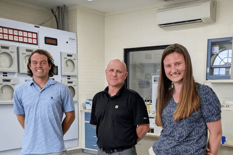 3 people standing in a water treatment facility