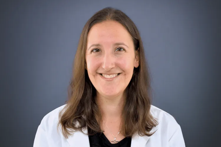 a person in a white coat smiling