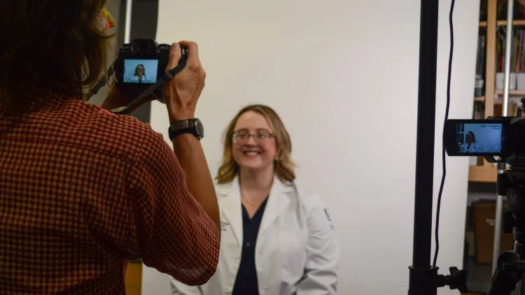 a woman in a white coat getting her picture taken