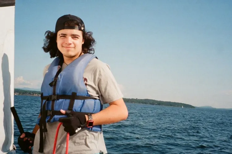 A smiling man in a life jacket on a boat.