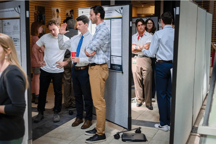 groups of people looking at Cancer Center research posters
