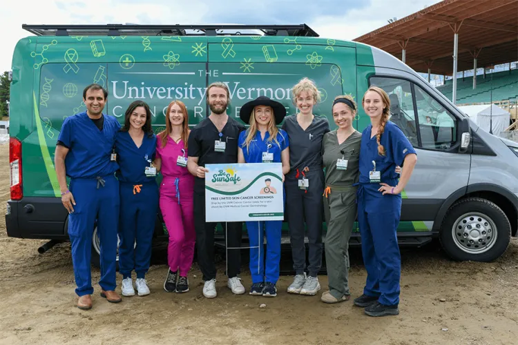 a group of health care providers posing in front of the Cancer Center van