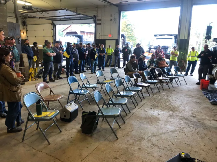 a group of people seated in a large garage