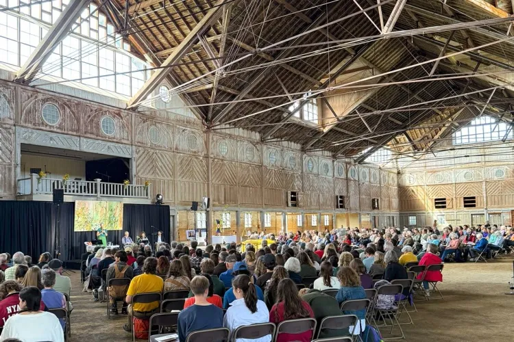 A crowd of people seated in the Breeding Barn at Shelburne Farms in VT