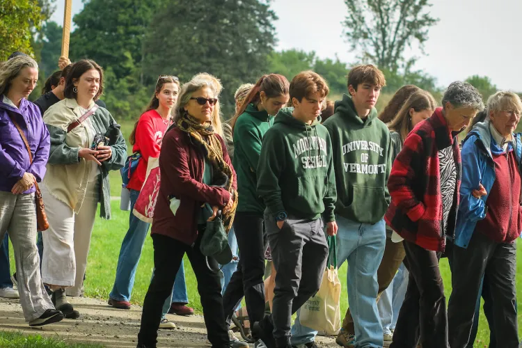 A group walking together in silent meditation, some are students, some are older community members