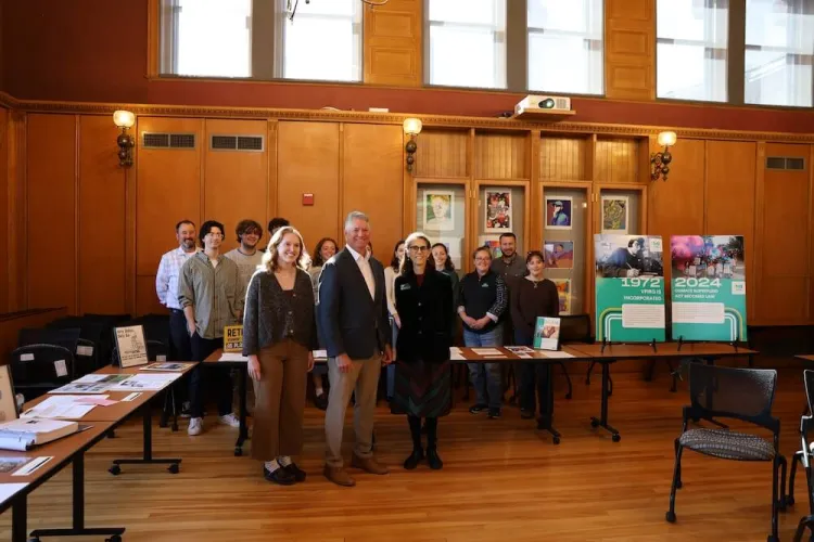 Group stands in front of VPIRG archives on display