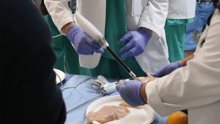 Medical students and residents practicing using a tissue stapler in a clinical simulation lab