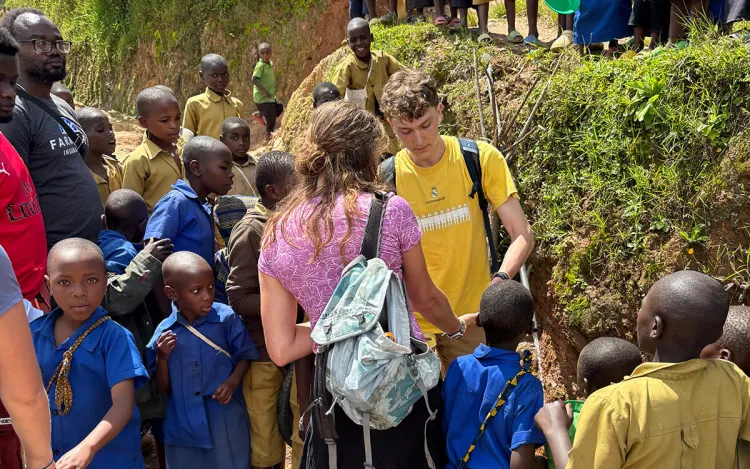 EWB students meet with community members in School children, aged 5 to 18, gathered outside the only school in Kajinge, Rwanda