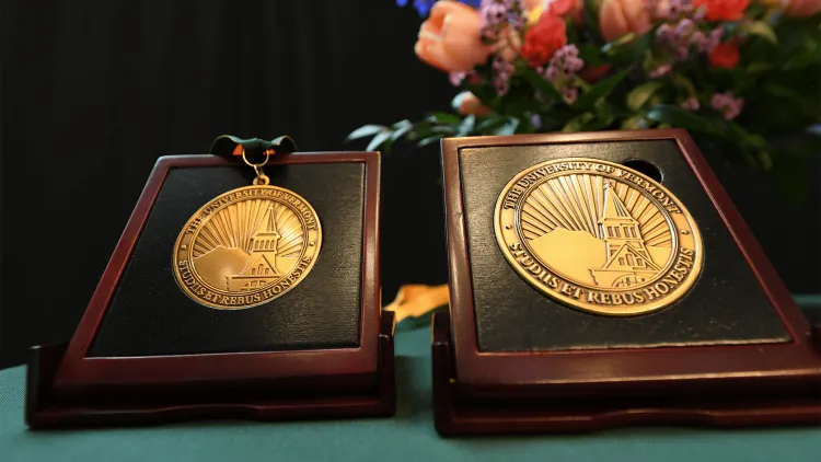 2 medallions on a green table with flowers in the background