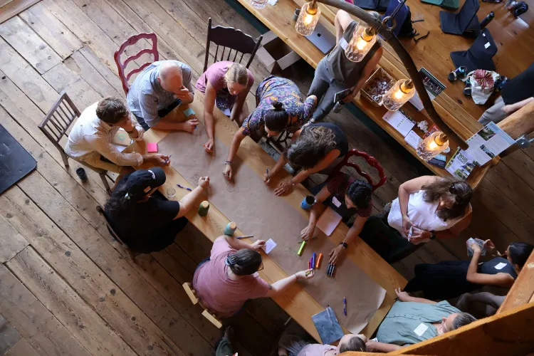 people gather aroound a wooden table