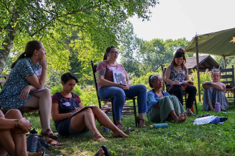 People sit around on the grass for a discussion