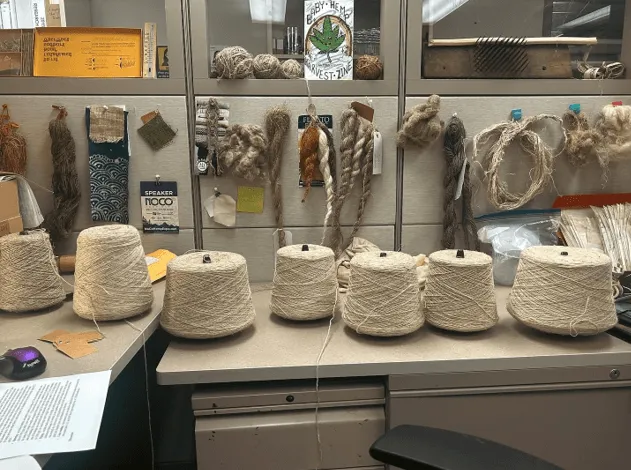 Spools of yarn at desk.