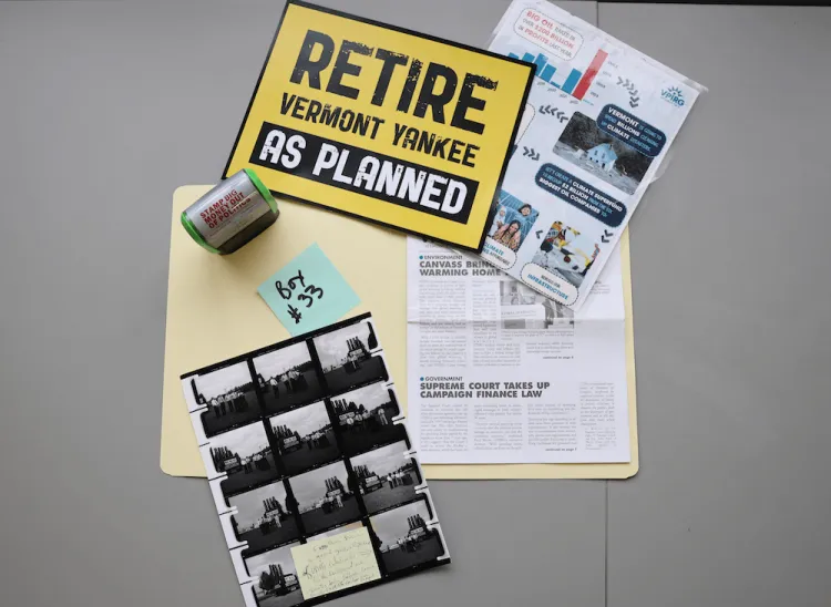 Collection close up of "retire vermont yankee" sign, photo contact sheet, self-inking stamper