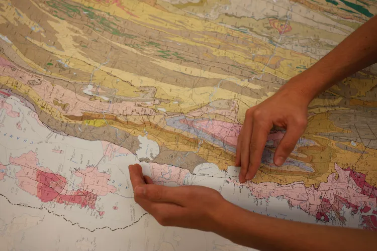 Two hands identify a specific section of land on a map.