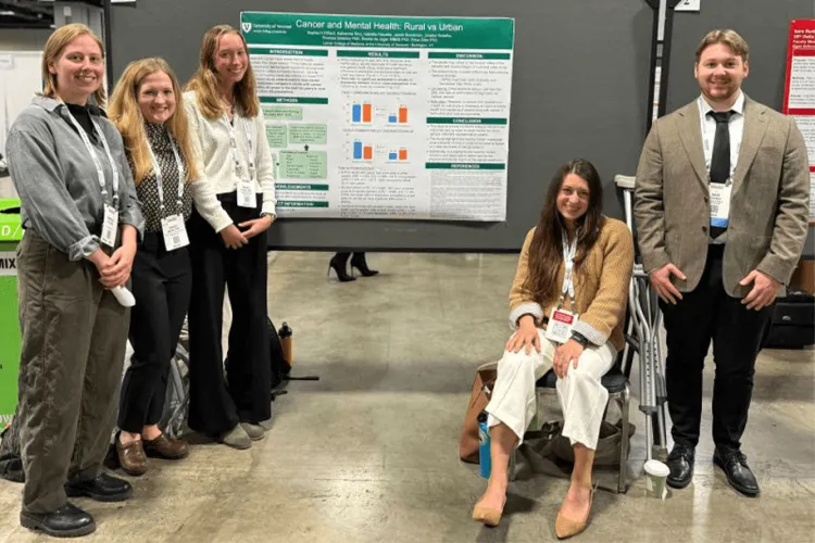 a group of people in front of a research poster at a conference