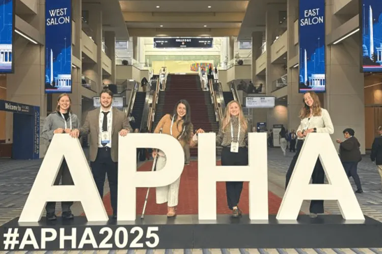 a group of people posing with an APHA sign at a conference