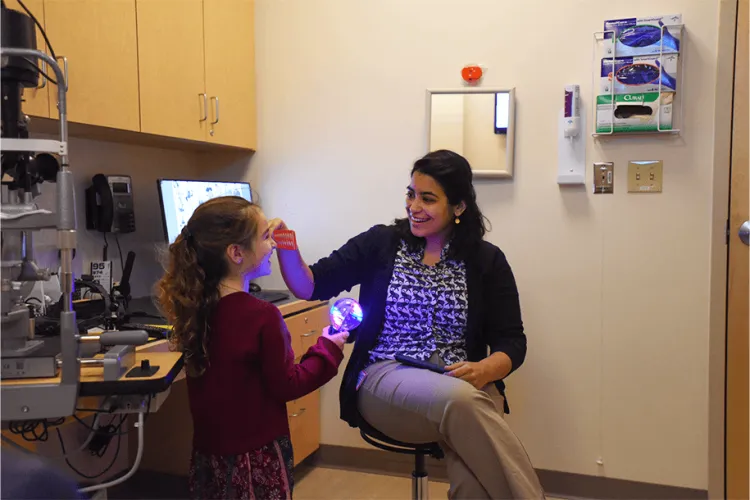 a person with a young patient in an eye doctor's office