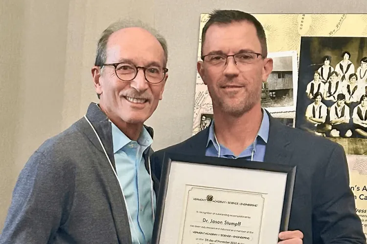 2 people posing with an award