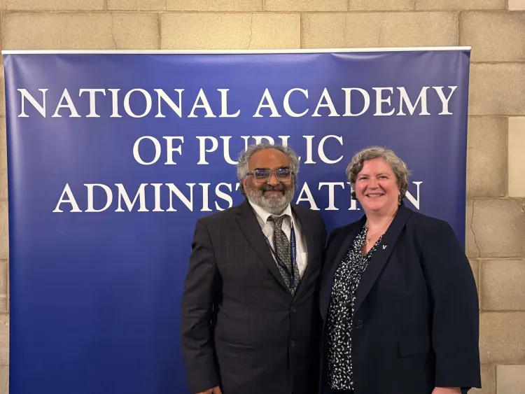 Man and woman standing in fromt of a sign