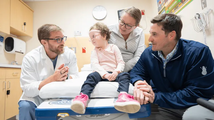 3 adults and a child in a medical exam room
