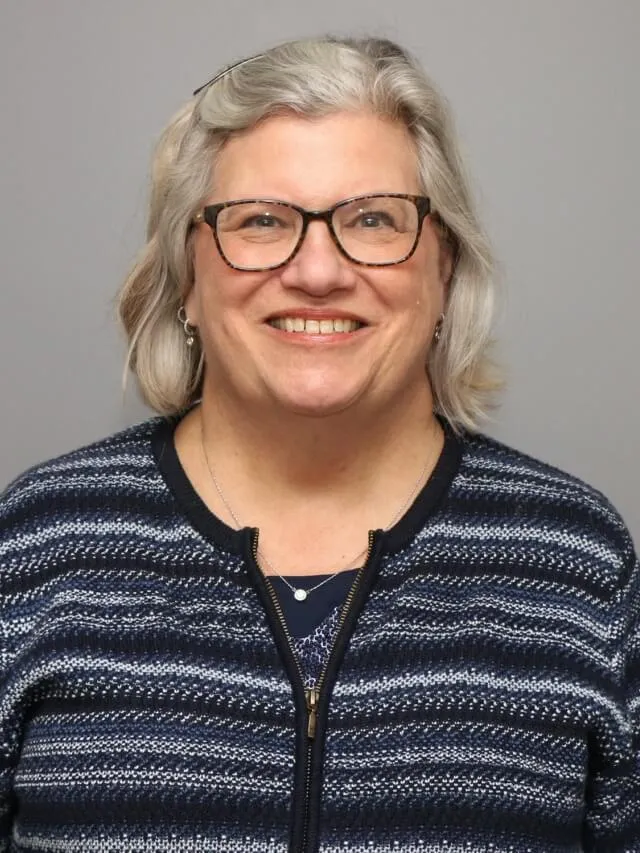 A person wearing glasses and a striped shirt